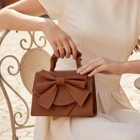 Cross camel  de mano con moño decorativo, elegante y femenina