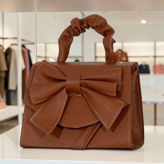 Cross camel  de mano con moño decorativo, elegante y femenina