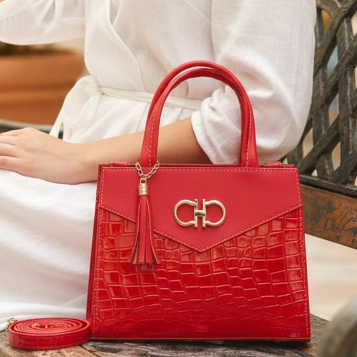 Bolsa cross rojo estructurada con detalle metálico y borla