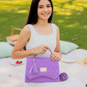 Bolsa cross morada estructurada con solapa geométrica y borla