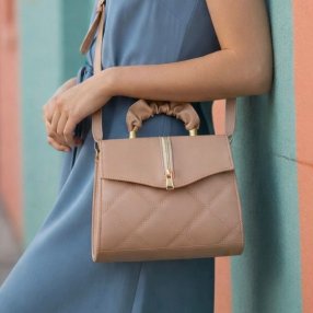 Crossmaquillaje estructurada con cierre decorativo y diseño acolchado