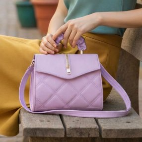 Cross lila estructurada con cierre decorativo y diseño acolchado