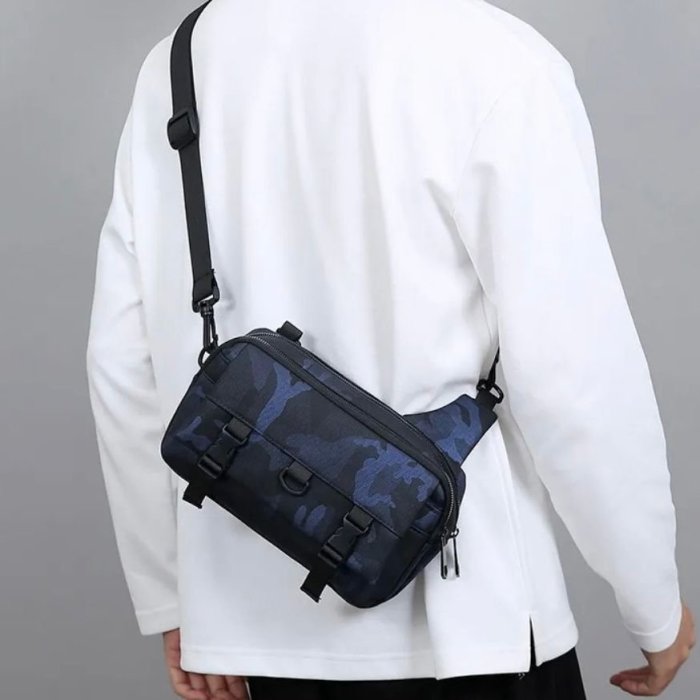 Bandolera gris tipo sling con múltiples compartimentos