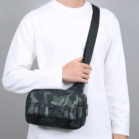 Bandolera verde tipo sling con múltiples compartimentos